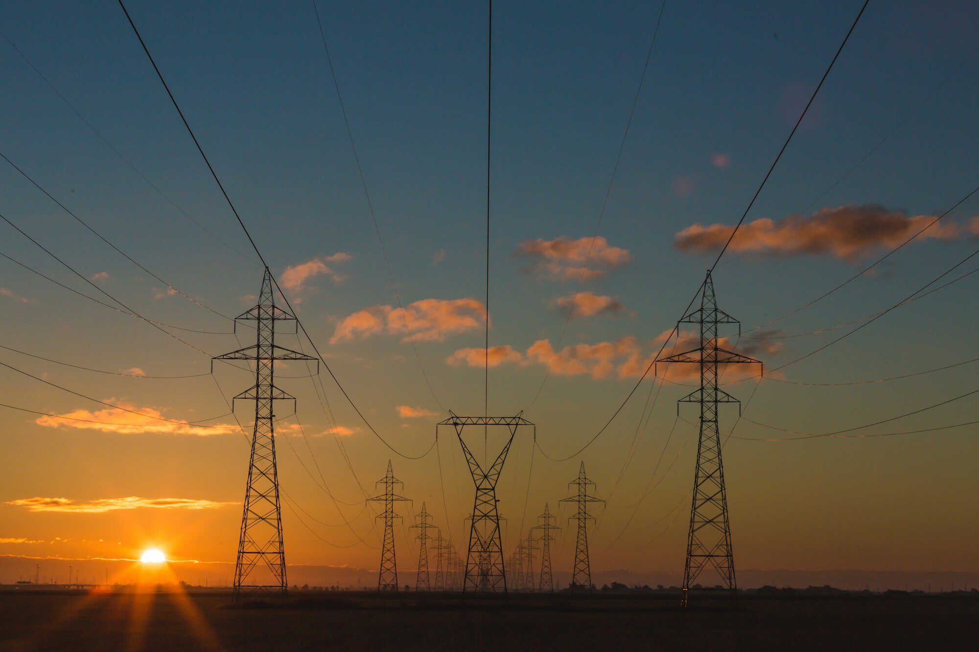 High voltage transmission towers at sunset